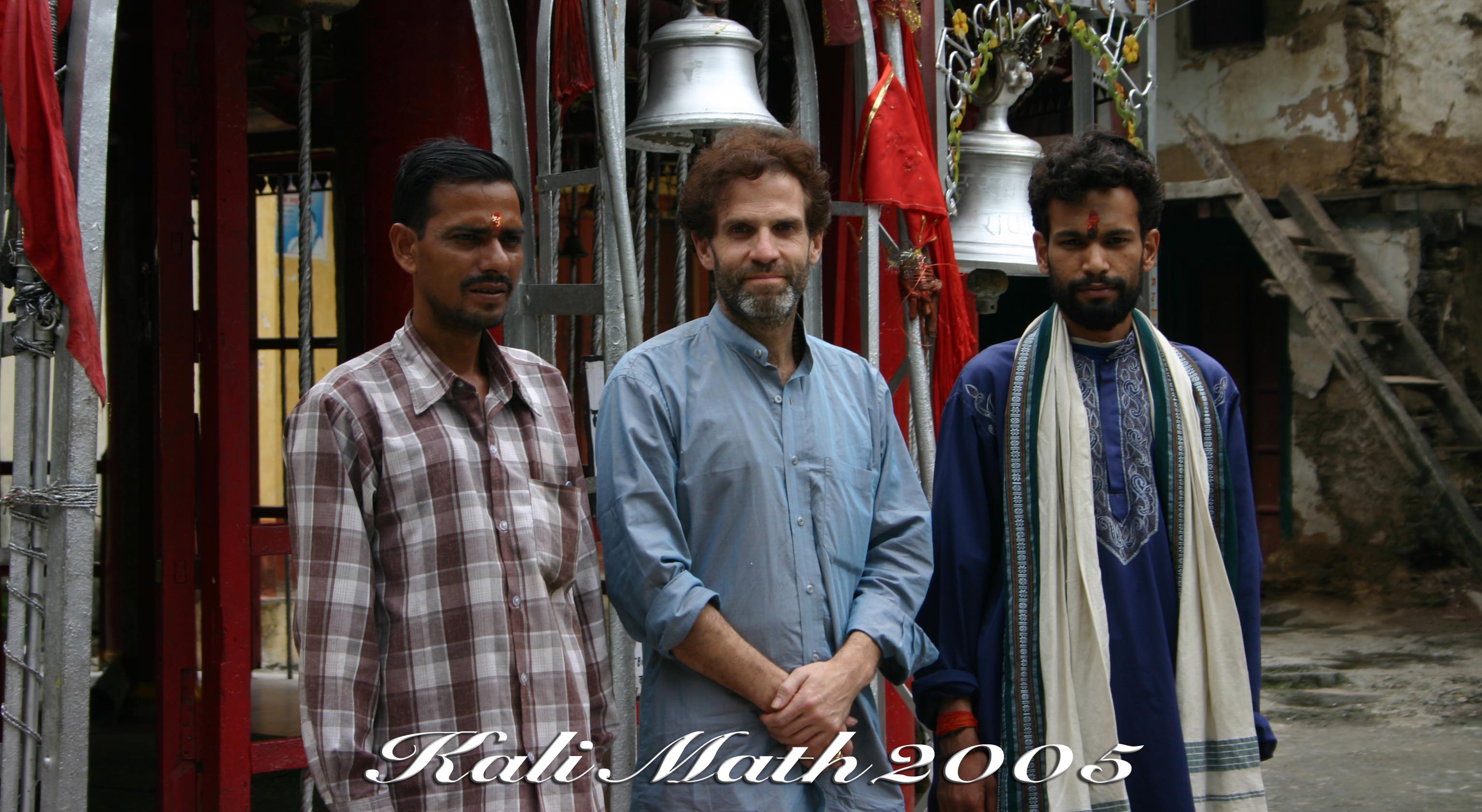 2005. Ganesh stand between two local villagers. The shrine is behind them, above them a bell used to herald newcomers to the town.
